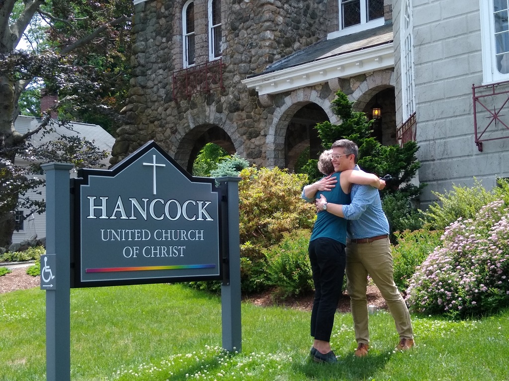 David hugging a staff member in front of the Hancock church.