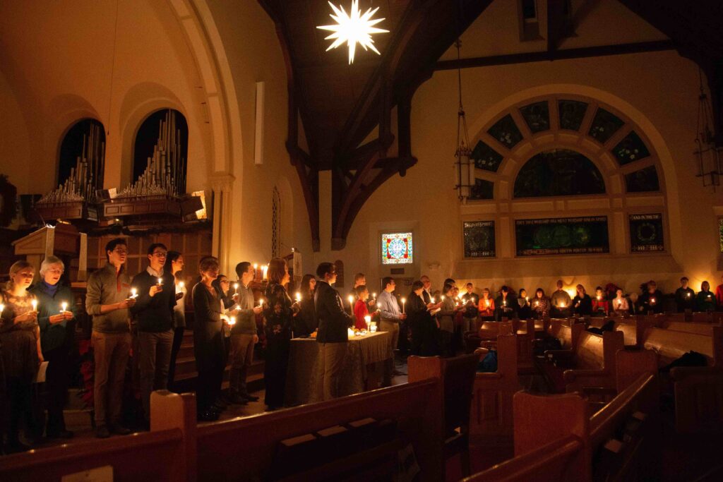 The Hancock Congregation holds candles during a Christmas Mass.
